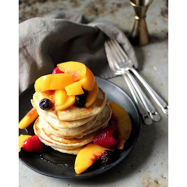  A lot of my favourite brunch fruit isn't in season yet (sad face) but I had a bunch of frozen fruit in the freezer. So I thawed it, chucked it in a pot and briefly infused it with a couple shots of bourbon and the fresh juice of a lemon. Then I made some fluffy homemade pancakes. And bam! Lazy lady's bourbon peach pancakes. Because, Sunday. For the pancakes: Place a large nonstick pan over medium heat. 1/4 C all purpose flour 1 Tbsp baking powder 2 tsp salt 2 tsp sugar Mix together in a large bowl. 1 large pasture-raised egg, lightly beaten 1 C 1% milk 1 tsp pure vanilla extract 1/2 Tbsp butter, melted Mix together in a second bowl. Pour the wet into the dry ingredients and whisk thoroughly until combined and little air bubbles form in the batter. When the pan is hot, drop a tsp of butter in there. Use a paper towel to coat the bottom of the pan. Ladle 1/3 C of the batter into the pan and cook until golden on the underside and the top is marked with little holes - about 3 to 4 minutes. Carefully (but assertively) flip the pancakes. Cool another 2 minutes or until cooked through. Keep warm in a pan in the oven at 200 degrees until all 'cakes are done. Between batches, wipe out the pan and add a new slather of butter to keep it from burning and ensure you get a nice golden colour on the pancakes each time. Serve with the bourbon laced fruit and more butter and real maple syrup. And coffee. Lots and lots of coffee. Happy Sunday my loves. ✨ 